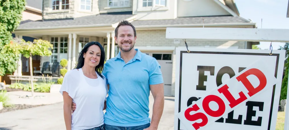 New homeowners in front of house